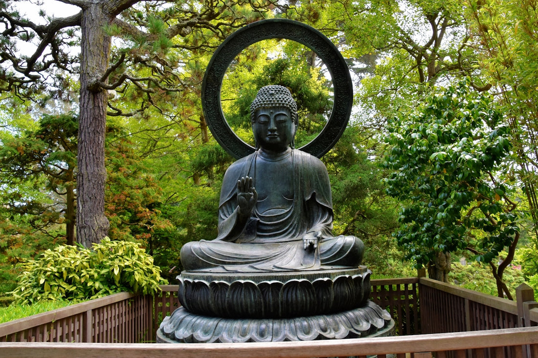 a statue of a buddha in a park setting