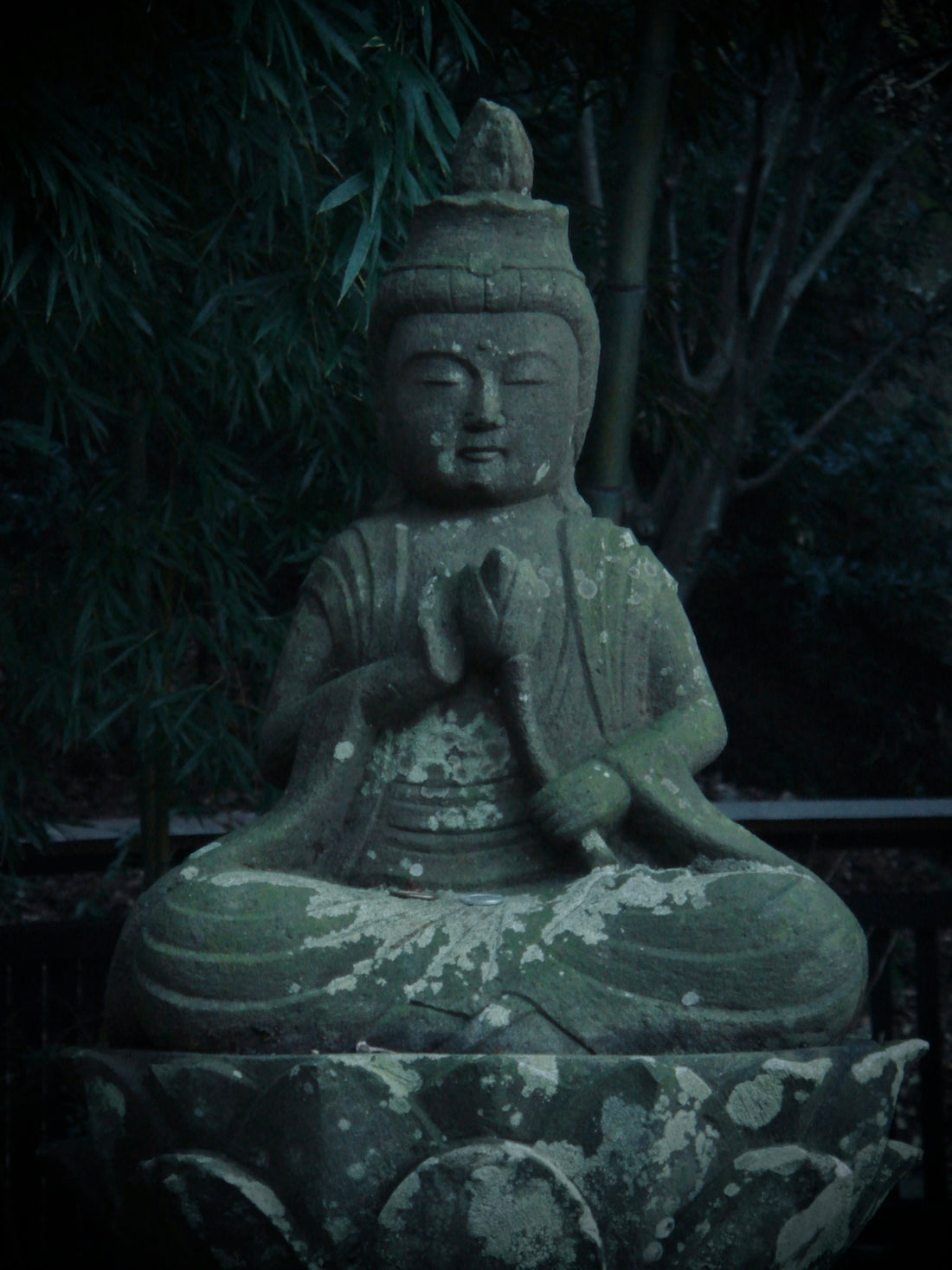 a buddha statue sitting on top of a stone slab