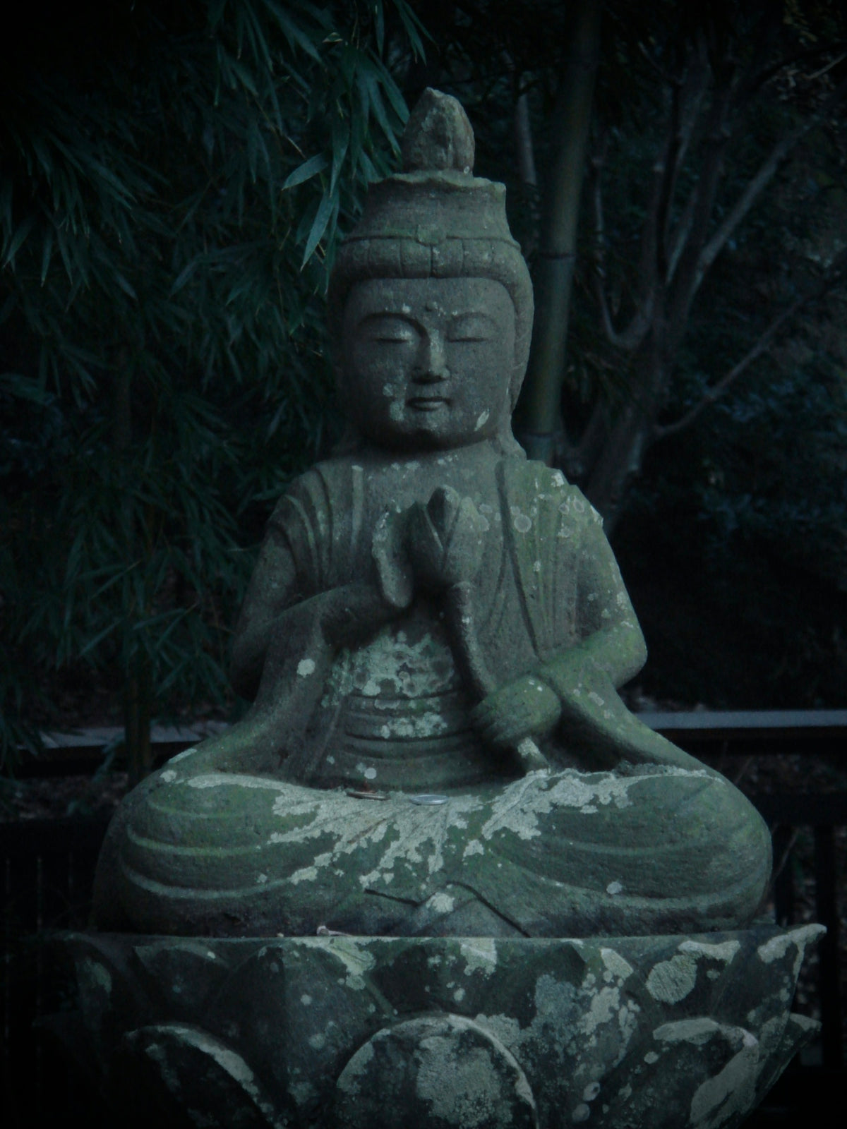a buddha statue sitting on top of a stone slab