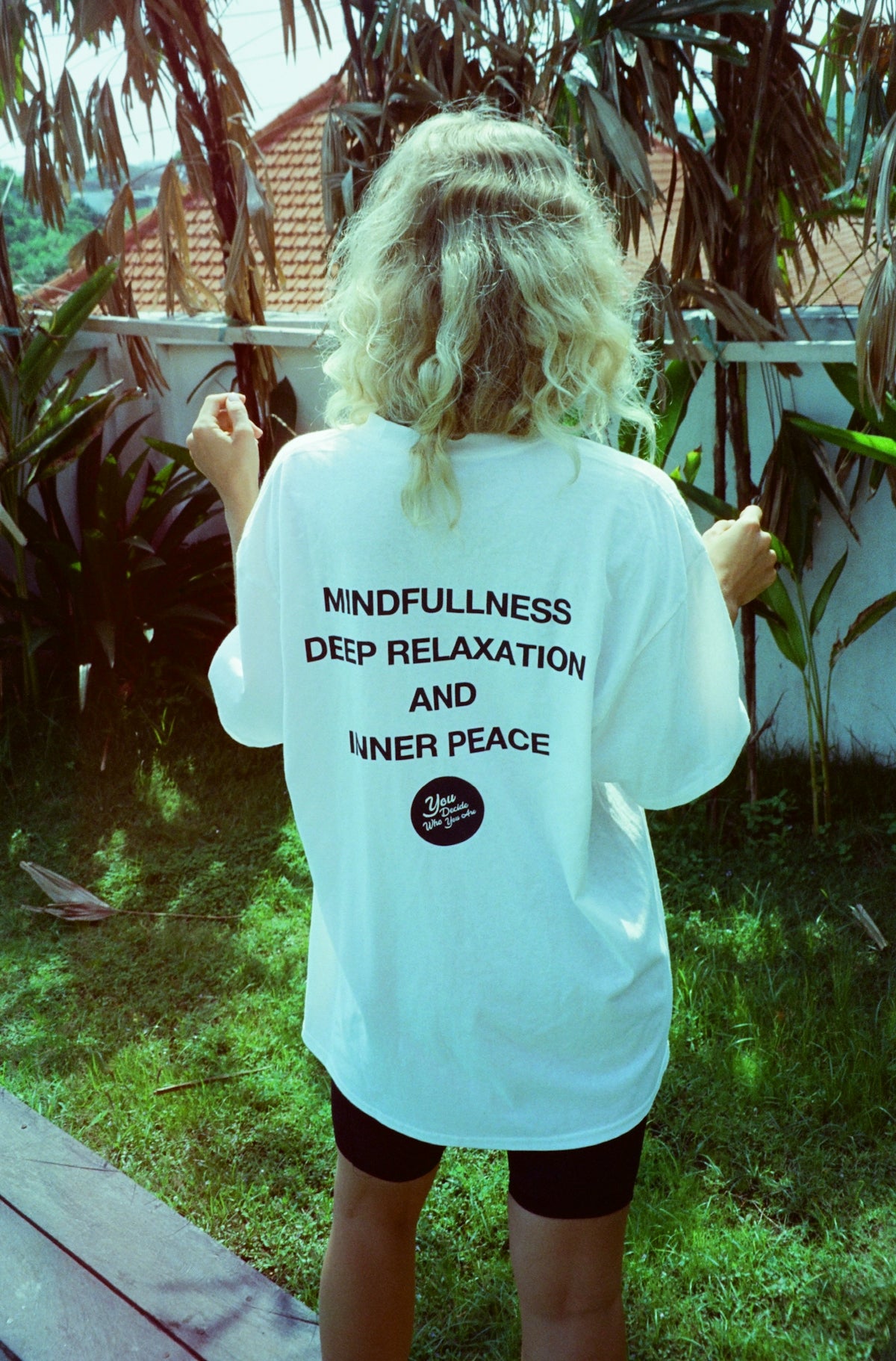 a woman wearing a white shirt that says mindfulness, deep relaxation and inner