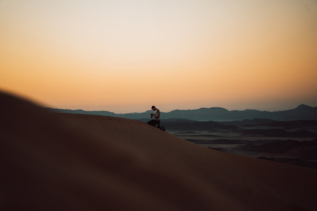 a person sitting on top of a sand dune