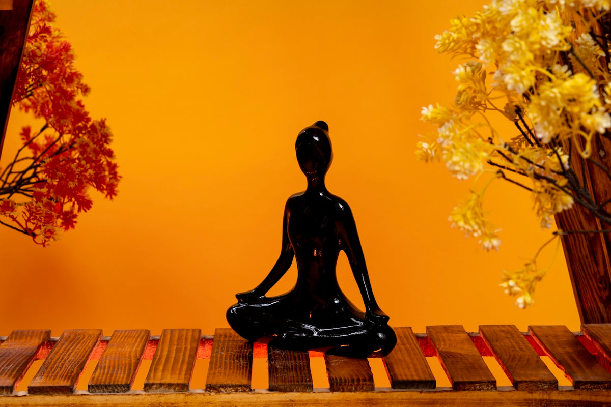 a statue of a person sitting in a yoga position